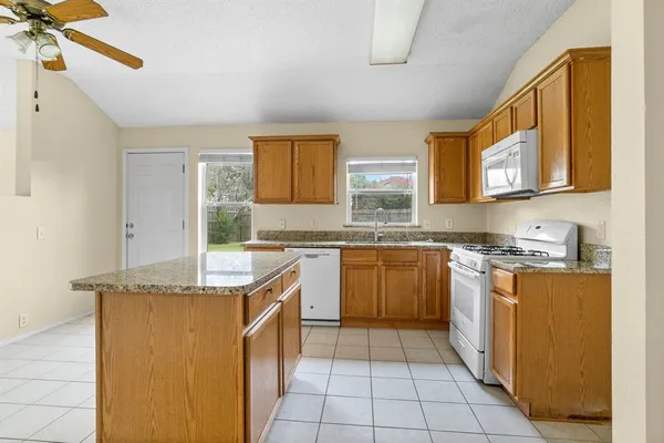 a kitchen with stainless steel appliances granite countertop a sink stove and cabinets
