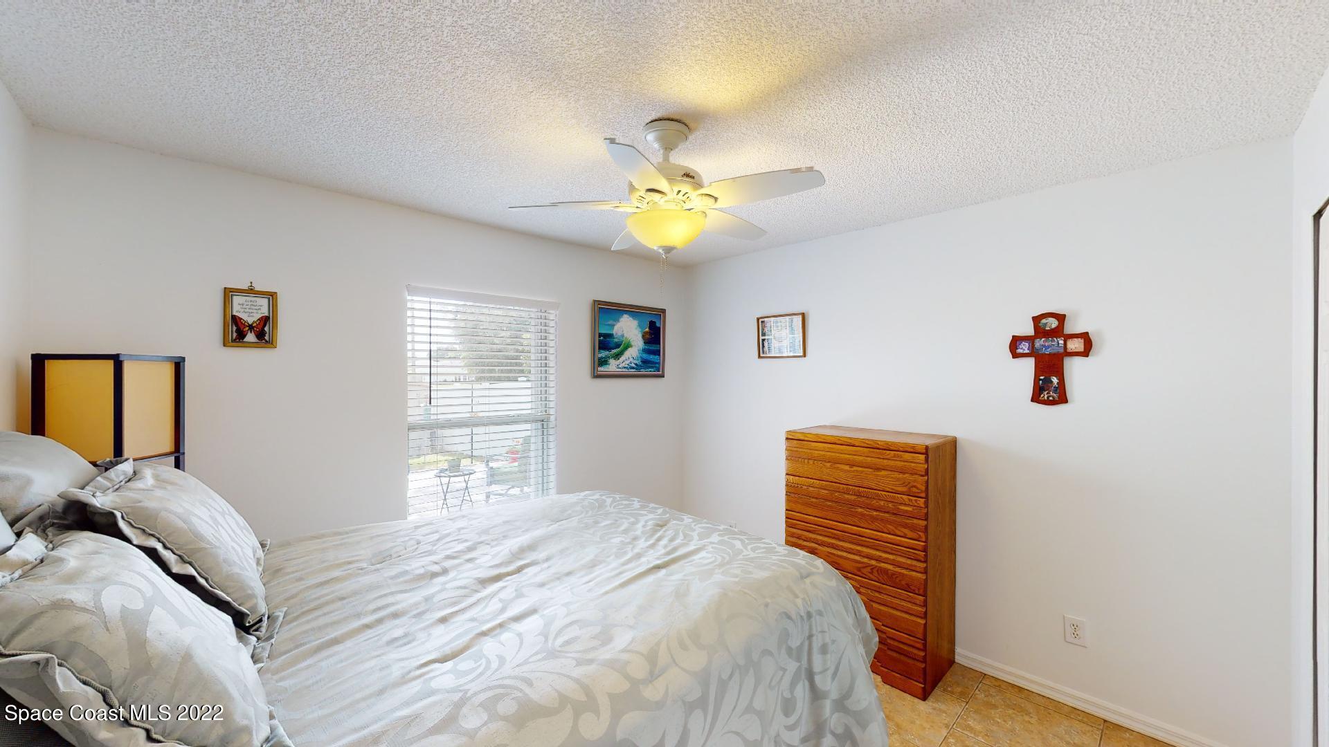 6801 Cecil Road Cocoa, FL 32927 - Photo 11 of 66 a bedroom with a bed and a chandelier