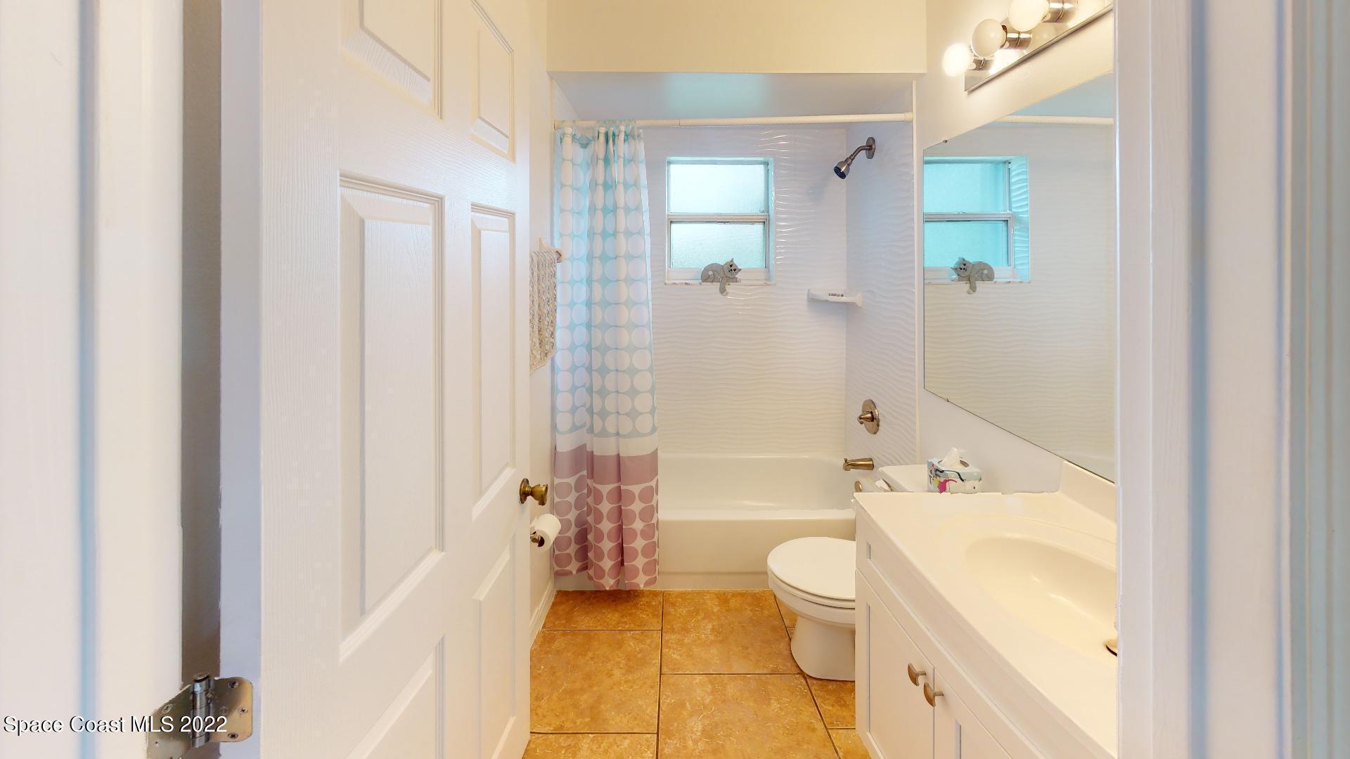 6801 Cecil Road Cocoa, FL 32927 - Photo 15 of 66 a bathroom with a bathtub shower sink mirror and toilet