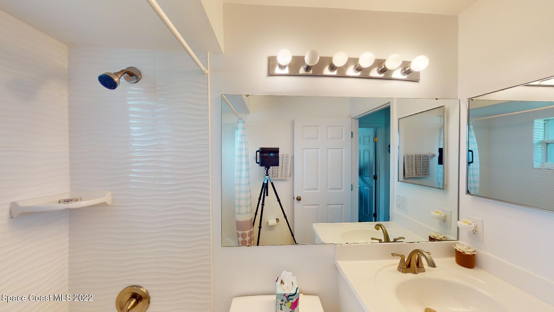 6801 Cecil Road Cocoa, FL 32927 - Photo 17 of 66 a bathroom with a sink a mirror and a shower