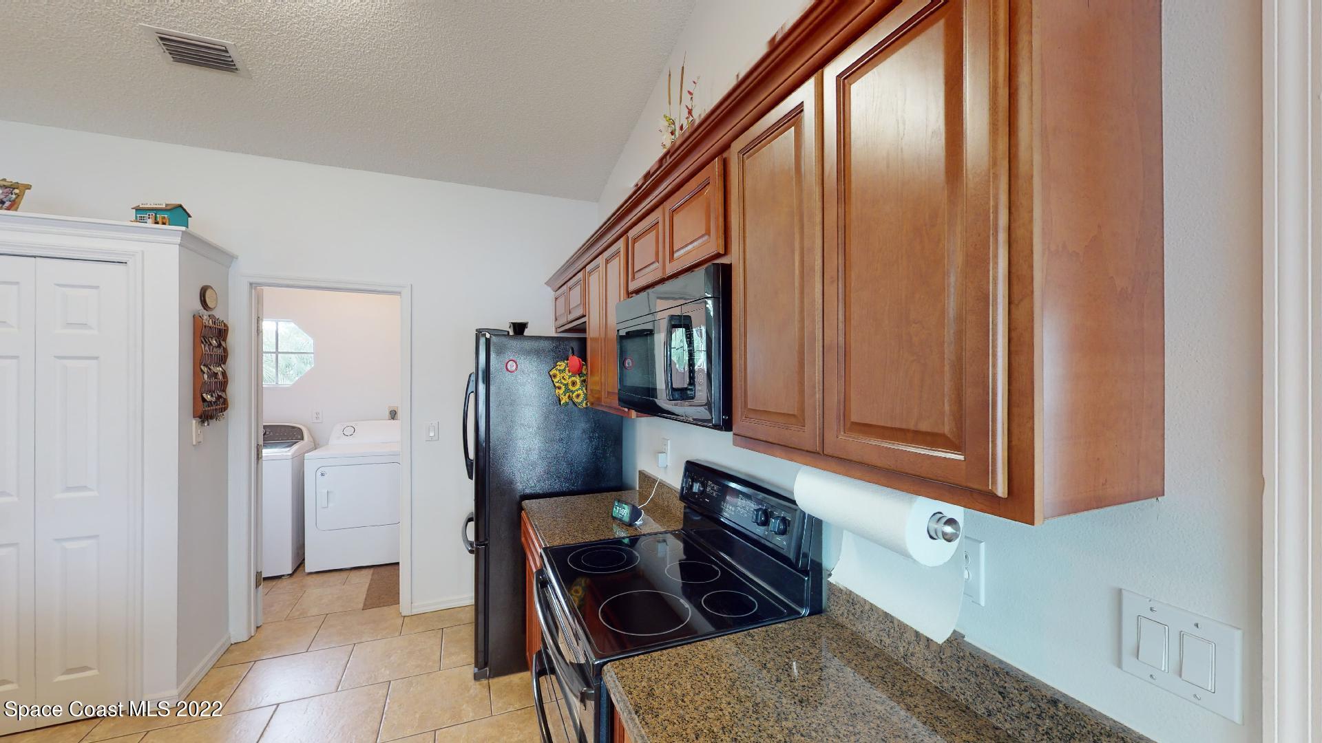 6801 Cecil Road Cocoa, FL 32927 - Photo 26 of 66 a kitchen with stainless steel appliances granite countertop a refrigerator and a stove top oven