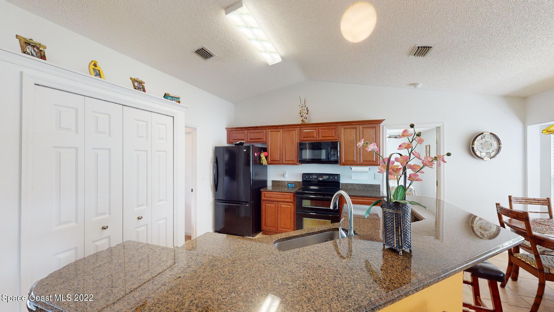 6801 Cecil Road Cocoa, FL 32927 - Photo 31 of 66 a kitchen with stainless steel appliances granite countertop a refrigerator and a stove top oven