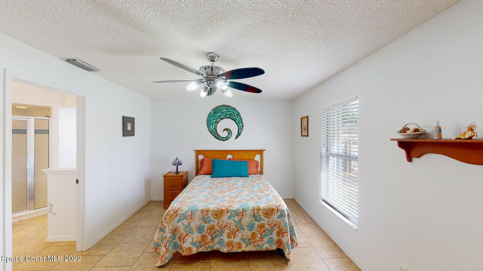 6801 Cecil Road Cocoa, FL 32927 - Photo 38 of 66 a bedroom with a bed and a chandelier