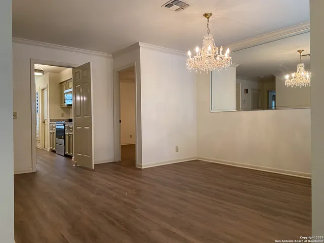 a room with a table and paintings on wall