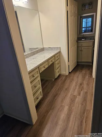 a bathroom with a granite countertop sink toilet a mirror a bathtub and shower