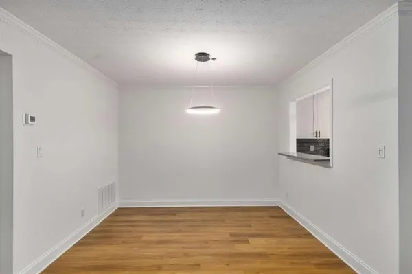 an empty room with wooden floor and fireplace