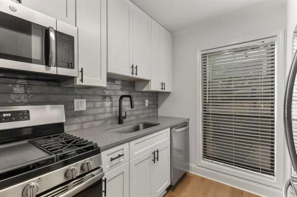 a kitchen with stainless steel appliances white cabinets and stove