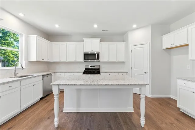 a kitchen with granite countertop white cabinets and white appliances