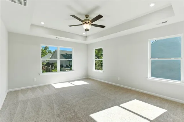 an empty room with windows and ceiling fan