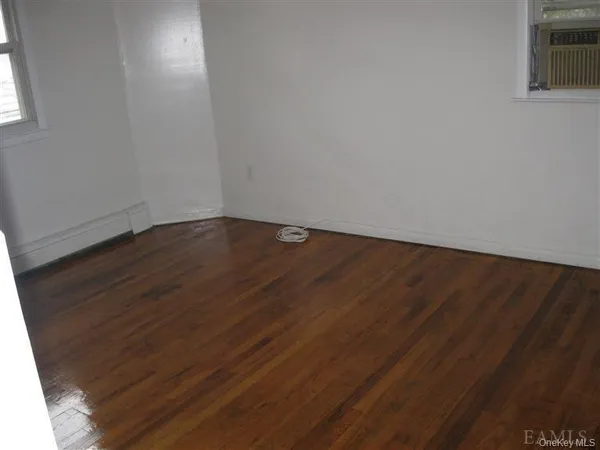 a view of a room with an empty space and wooden floor