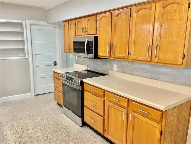 a kitchen with stainless steel appliances granite countertop a stove a sink and a microwave