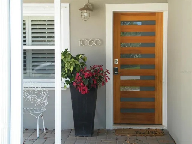 a front view of a house with a potted plant and a window