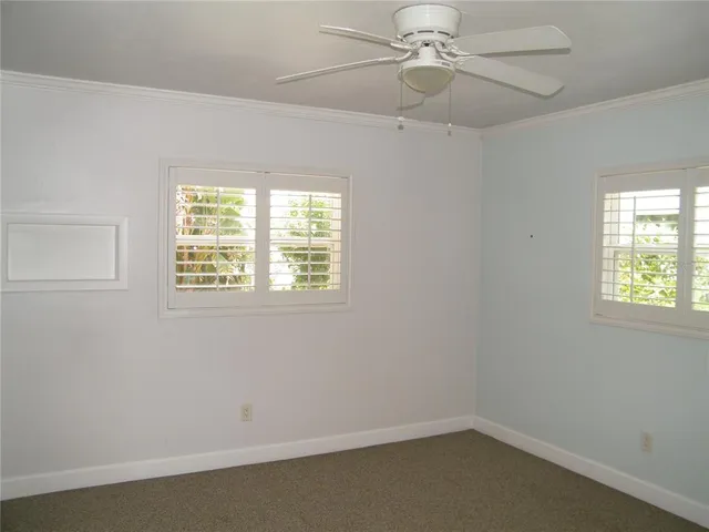 an empty room with a window and ceiling fan