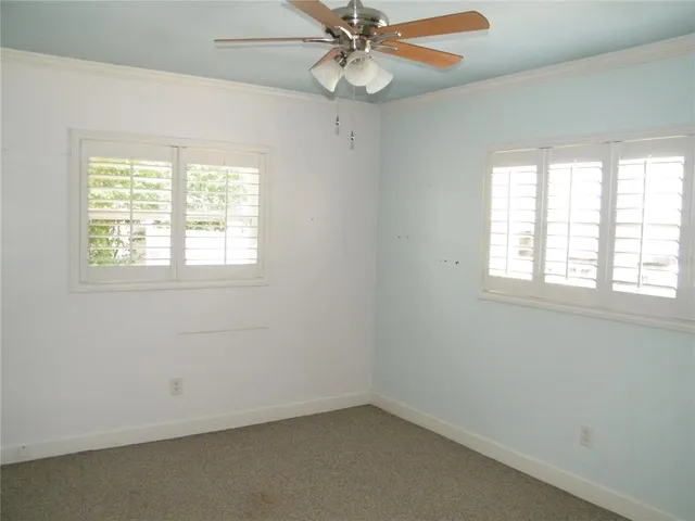 an empty room with a window and a fan