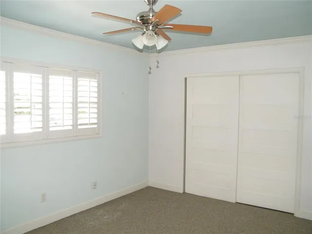 an empty room with a window and a fan