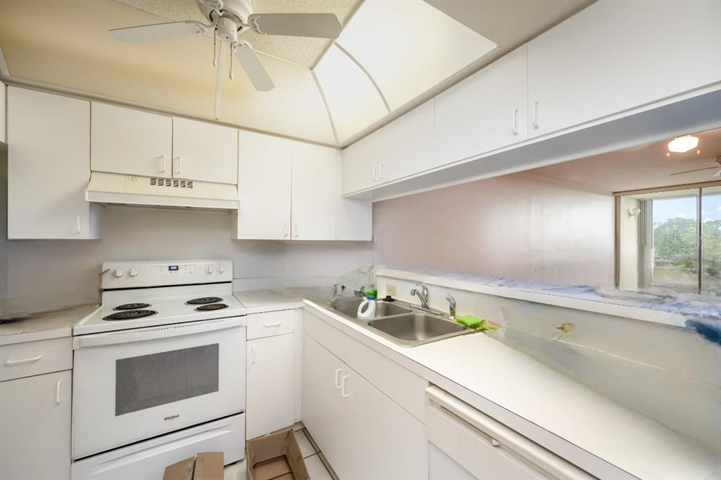 1420 Huntington Lane, Unit 2502 Rockledge, FL 32955 - Photo 8 of 26 a kitchen with granite countertop a sink cabinets and stainless steel appliances
