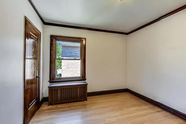a view of a room with wooden floor and a window