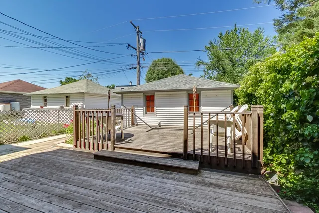 a view of a house with wooden deck front of house