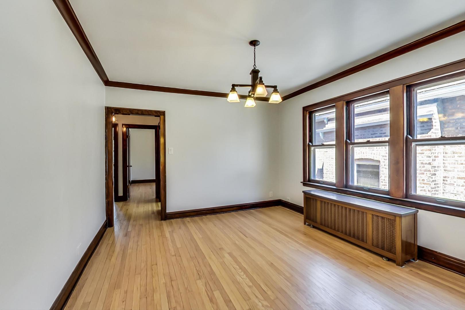 1814 Wesley Avenue, Unit 1 Berwyn, IL 60402 - Photo 5 of 26 a view of an empty room with a window and wooden floor