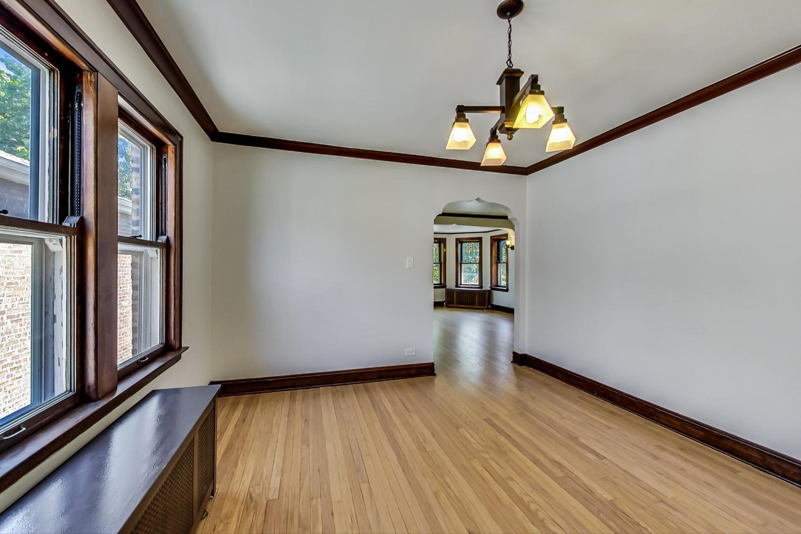 1814 Wesley Avenue, Unit 1 Berwyn, IL 60402 - Photo 7 of 26 a view of a room with wooden floor staircase and a ceiling fan