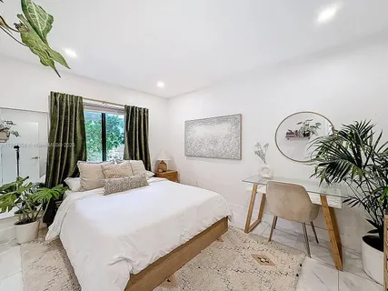 a bedroom with bed and a potted plant