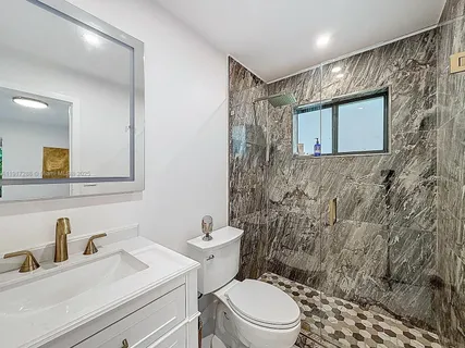 a bathroom with a sink a toilet and shower