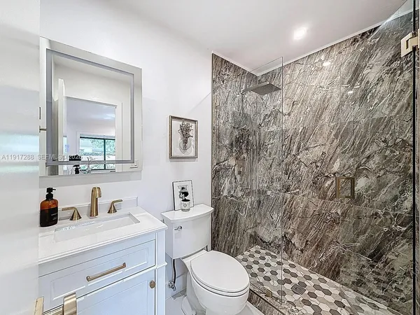 a bathroom with a toilet sink vanity and mirror