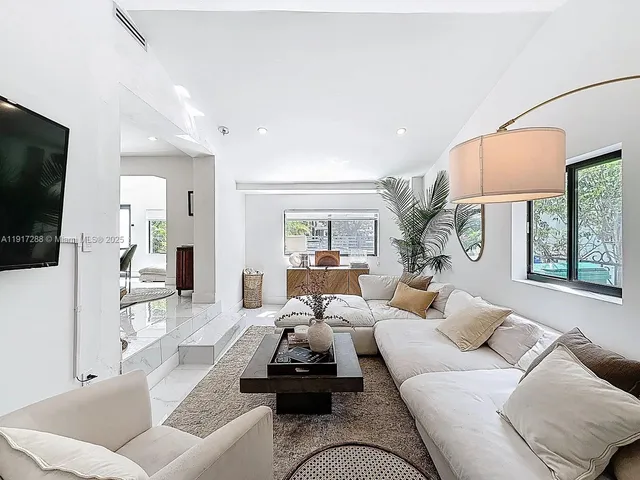 a living room with furniture a flat screen tv and a large window