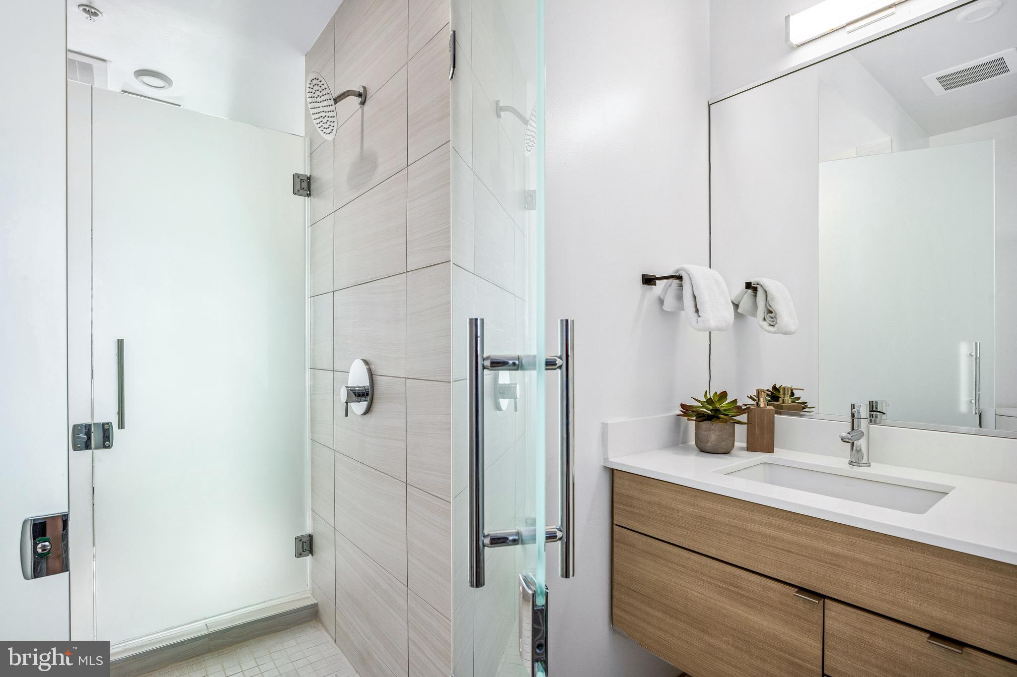 1550 11th Street Northwest, Unit 407 Washington, DC 20005 - Photo 11 of 20 a bathroom with a shower sink and mirror