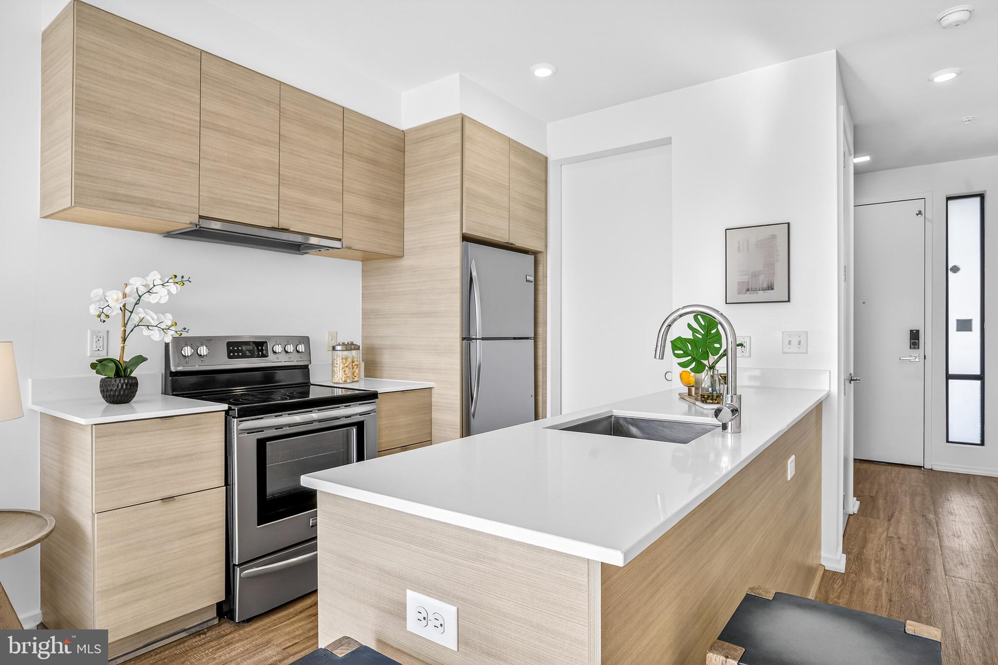 1550 11th Street Northwest, Unit 407 Washington, DC 20005 - Photo 5 of 20 a kitchen with stainless steel appliances a stove a refrigerator a sink a counter space and cabinets