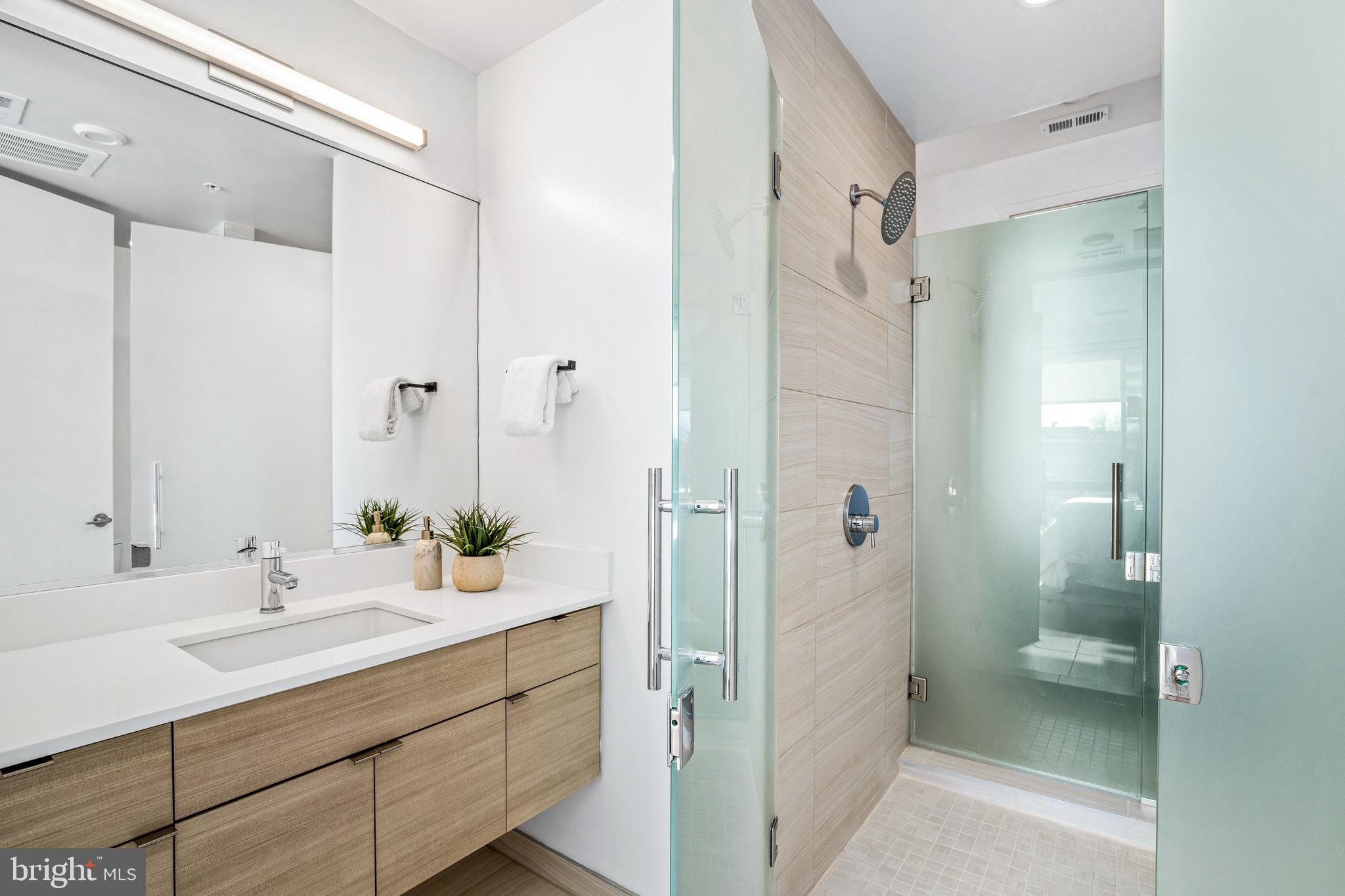 1550 11th Street Northwest, Unit 407 Washington, DC 20005 - Photo 9 of 20 a bathroom with a shower sink and mirror