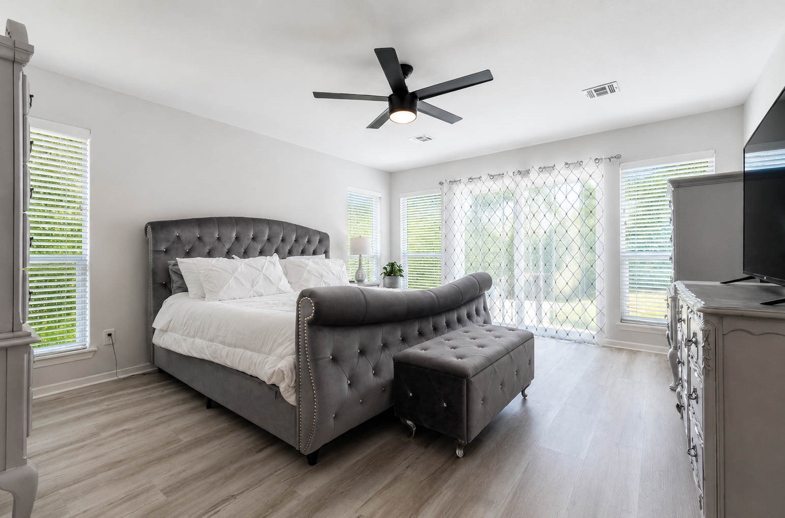 630 South Fry Road Katy, TX 77450 - Photo 22 of 48 Spacious bedroom with abundant natural light from large sliding doors leading to the backyard, and sleek modern ceiling fan.