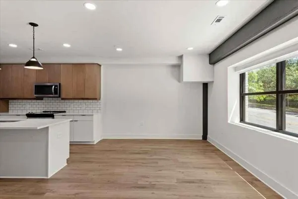a kitchen with stainless steel appliances granite countertop a sink a stove and a wooden floors