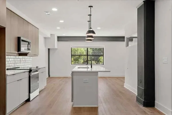 a view of a kitchen with a sink a refrigerator and a stove top oven