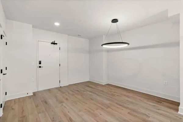 a view of a room with a ceiling fan and wooden floor