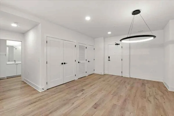 a view of an empty room with wooden floor