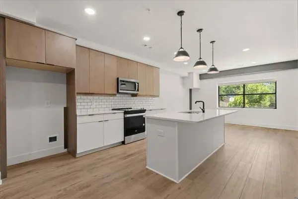 a kitchen with kitchen island white cabinets and stainless steel appliances