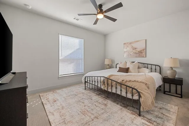 a spacious bedroom with a bed and a flat screen tv