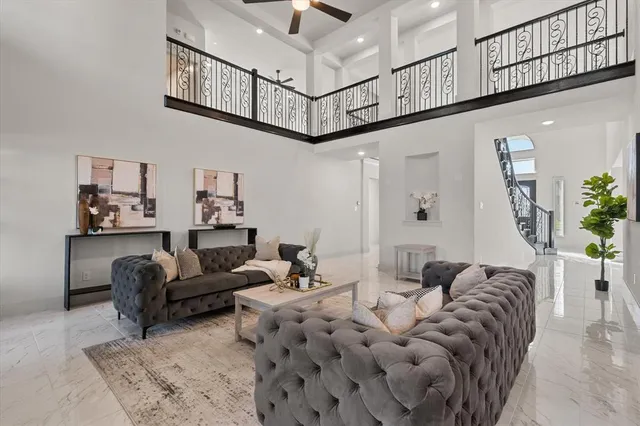 a living room with furniture and a ceiling fan