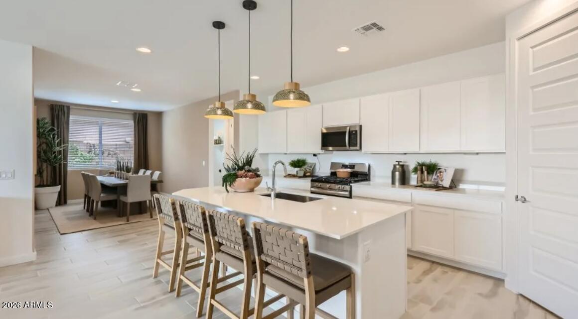 15602 West Miami Street Goodyear, AZ 85338 - Photo 3 of 25 a kitchen with a dining table chairs sink and cabinets