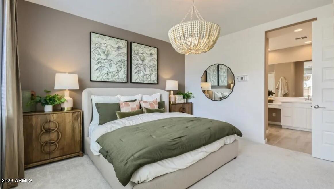 15602 West Miami Street Goodyear, AZ 85338 - Photo 7 of 25 a bedroom with bed and a chandelier