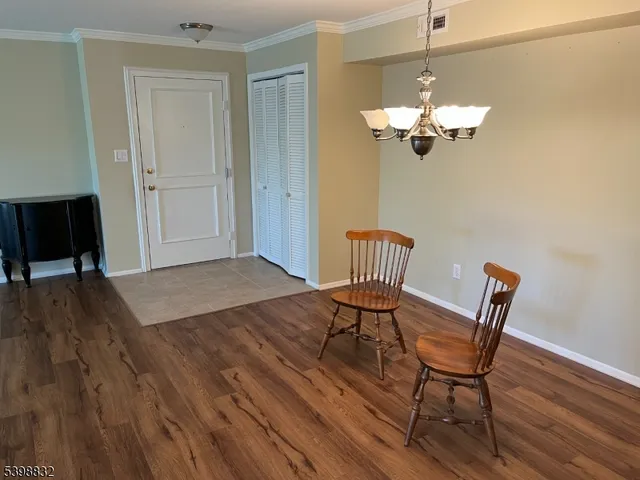 a view of a dining room with wooden floor and chandelier