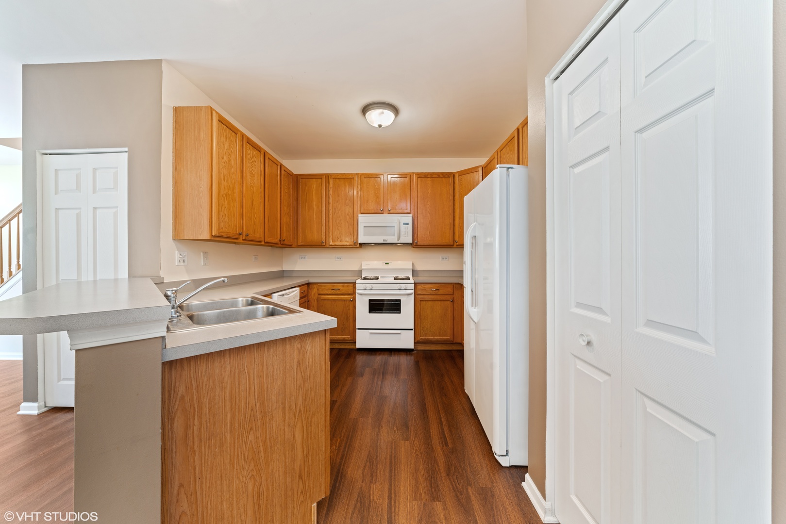 131 Springbrook Trail South Oswego, IL 60543 - Photo 5 of 16 a kitchen with a sink a stove cabinets and wooden floor