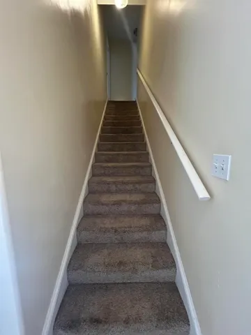 a view of an empty room with a window and chandelier fan