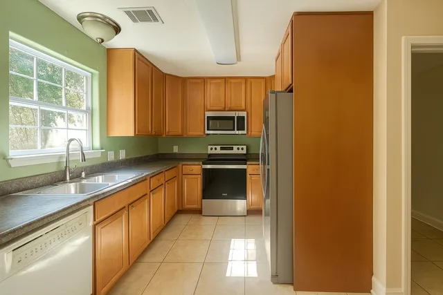 a kitchen with stainless steel appliances granite countertop a refrigerator and a sink