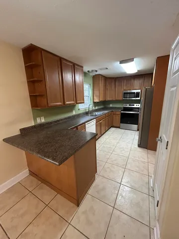 a kitchen with granite countertop a refrigerator and a sink