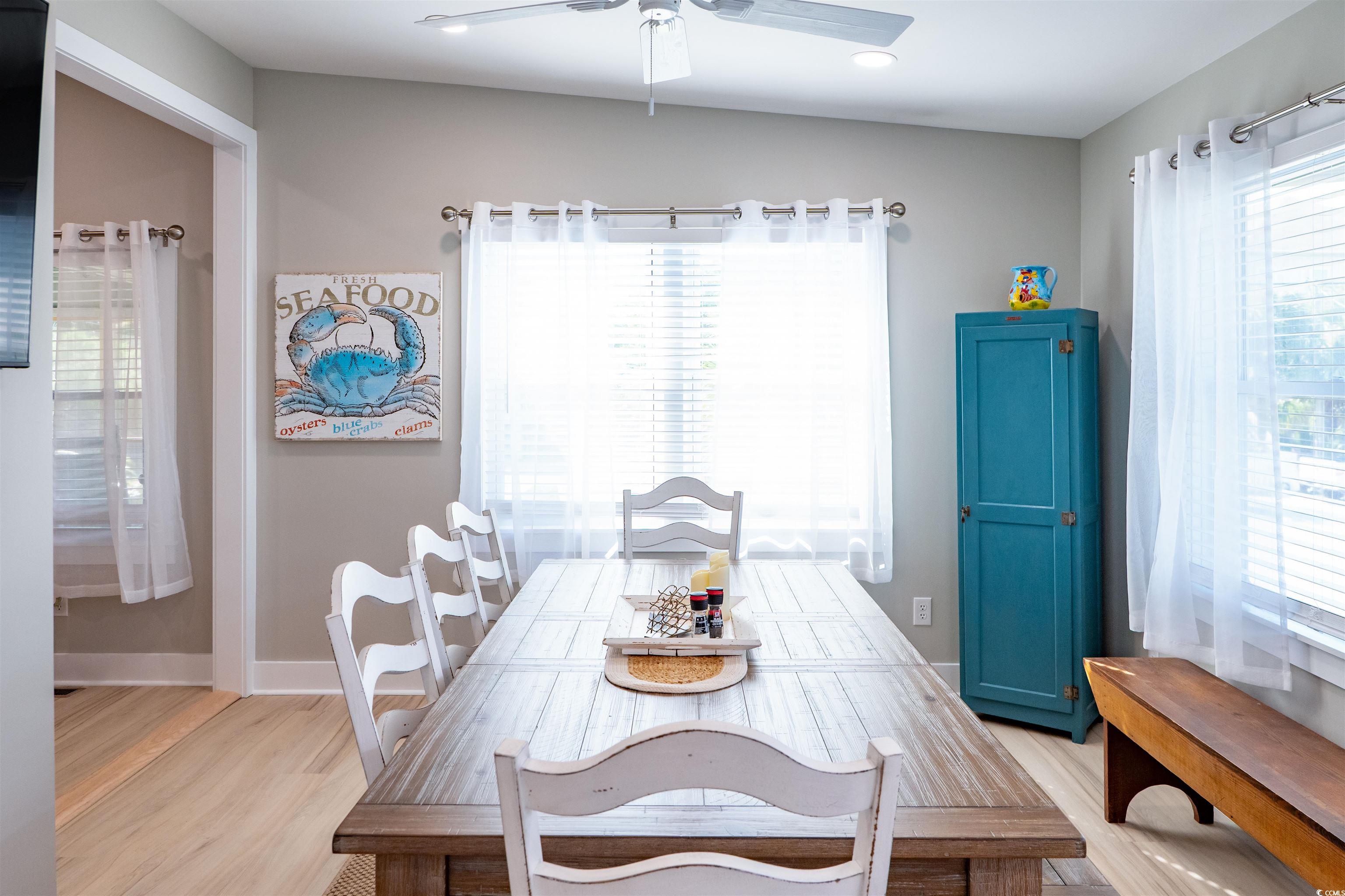 415 Sundial Drive Pawleys Island, SC 29585 - Photo 13 of 35 Kitchen with stainless steel appliances, white cabinets, backsplash, a ceiling fan, and light stone countertops