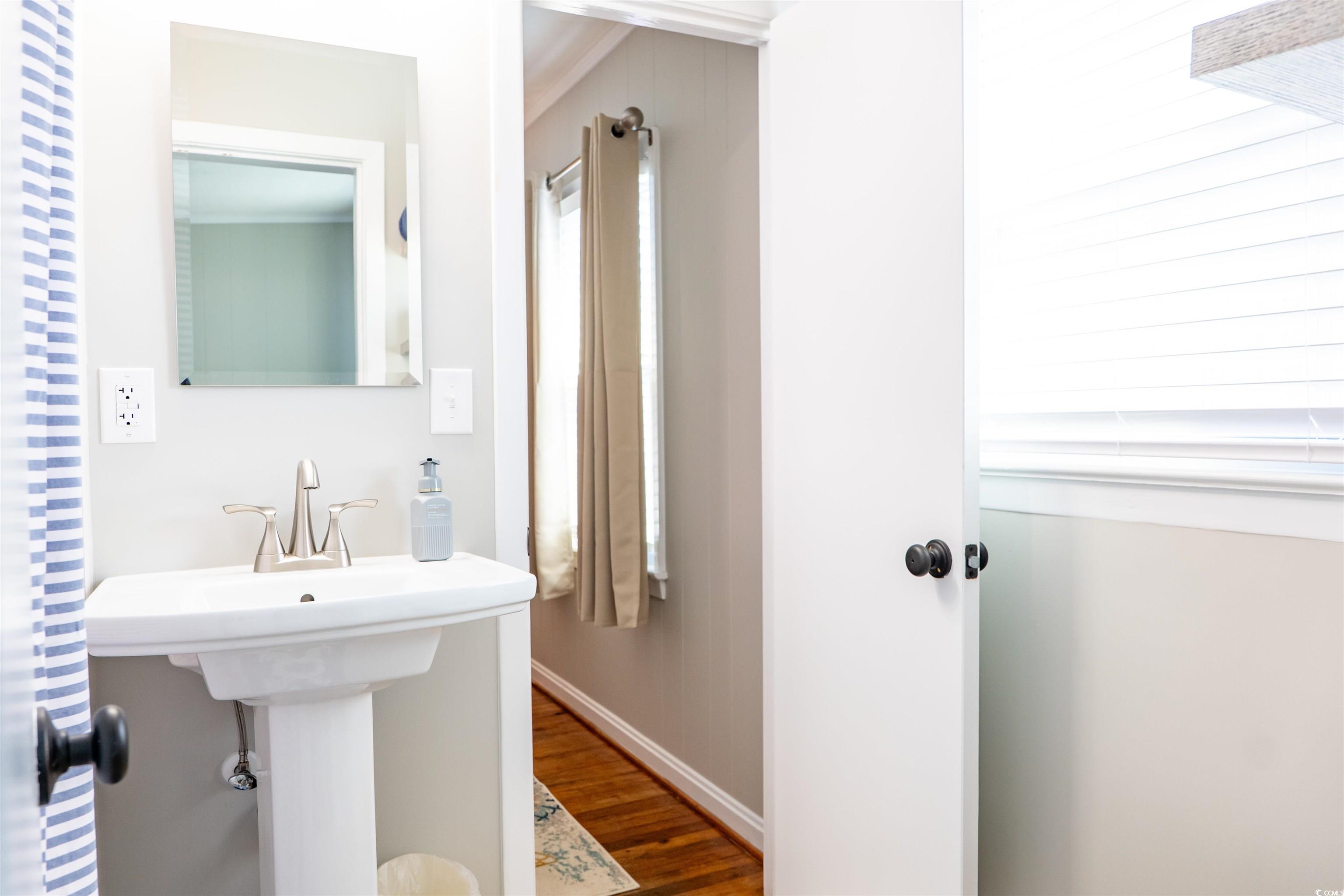 415 Sundial Drive Pawleys Island, SC 29585 - Photo 19 of 35 Bedroom with crown molding, wood finished floors, and a decorative wall