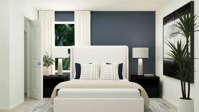 a bedroom with a large bed and a potted plant