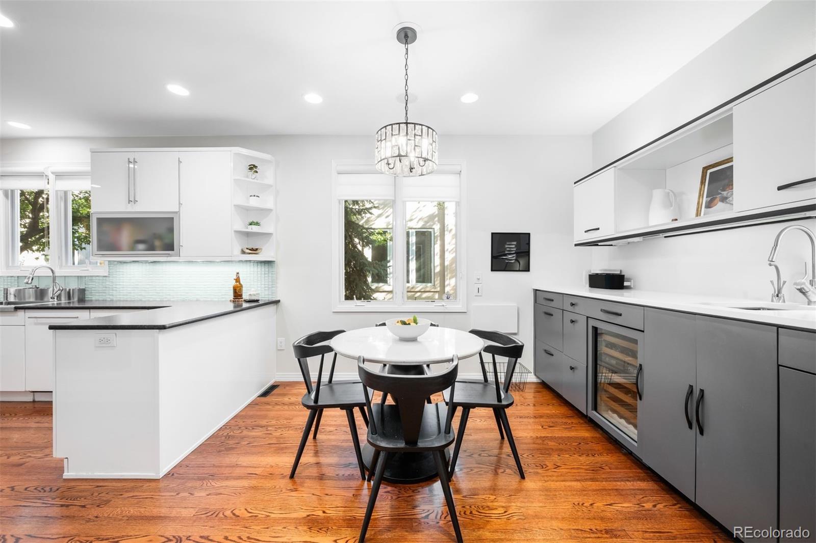 361 Detroit Street Denver, CO 80206 - Photo 11 of 46 a kitchen with stainless steel appliances kitchen island granite countertop a dining table chairs and white cabinets